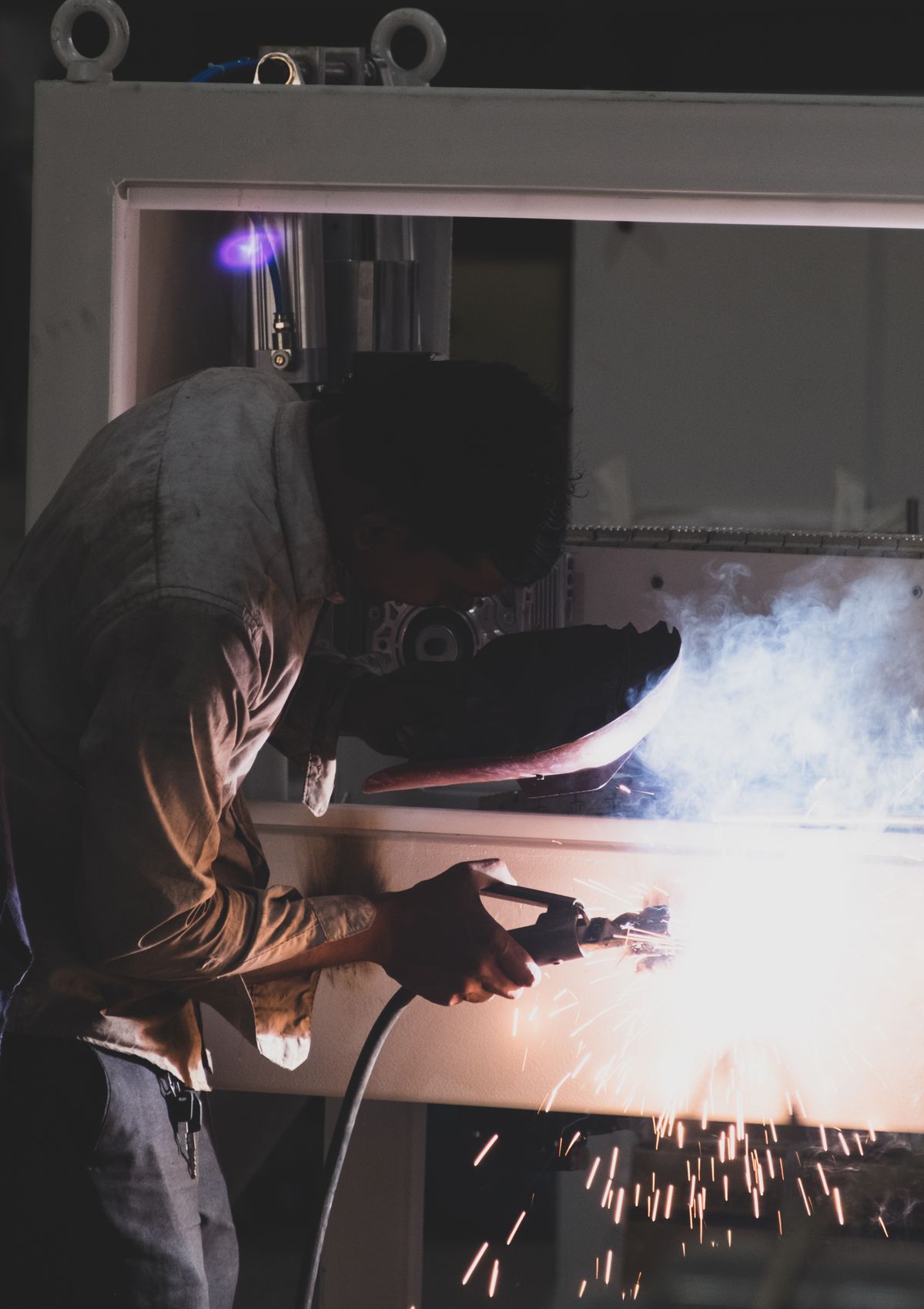 Indian welder at work in a steel fabrication workshop